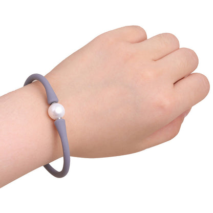 Wit elastisch zoetwaterparel armband met grijze band om pols | Greyly