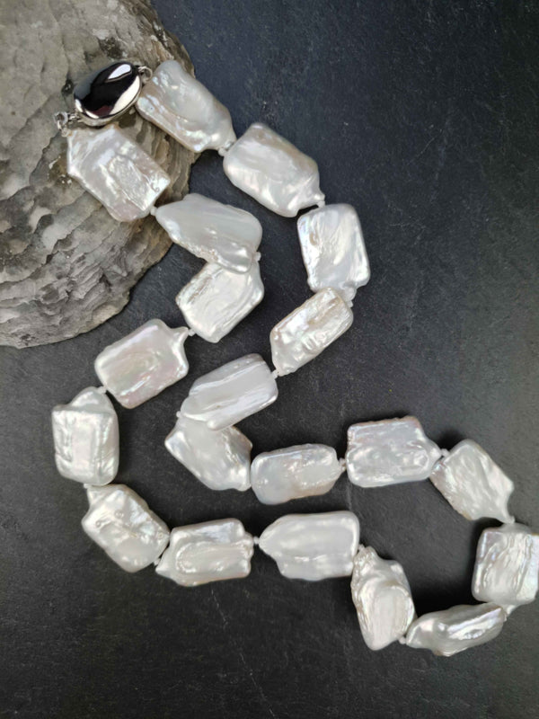Witte zoetwater parelketting met vierkante parels en sterling zilver (925) liggend op leisteen | Rena