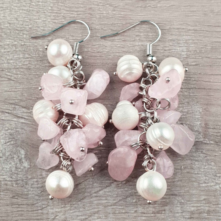 Witte zoetwater parel oorbellen met rozenkwarts en sterling zilver (925) liggend op hout | Pearl Rosé Quartz Chip